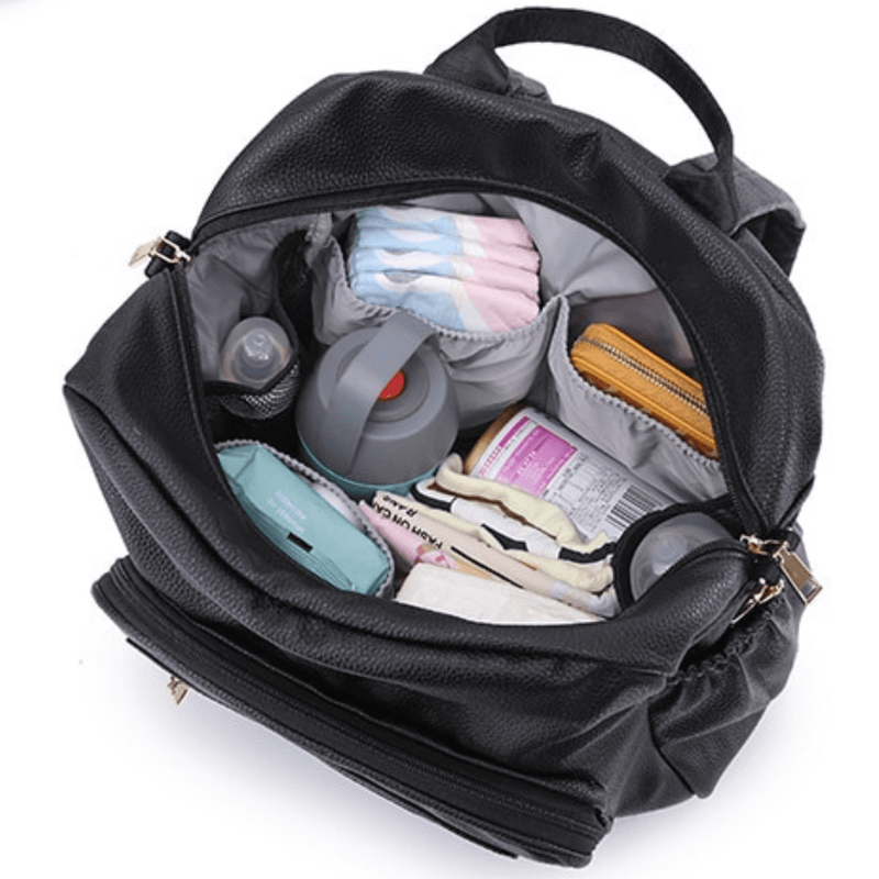 A Mother and Baby Lily - Black diaper bag filled with diapers, wipes and other items.