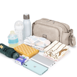 Various baby essentials and personal items including a Pram Caddy from Mother and Baby, baby bottles, diapers, a swaddle, smartphone, and a wallet, arranged neatly on a white background.
