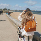 A woman with a Chloe - Caramel stroller from Mother and Baby on the beach.