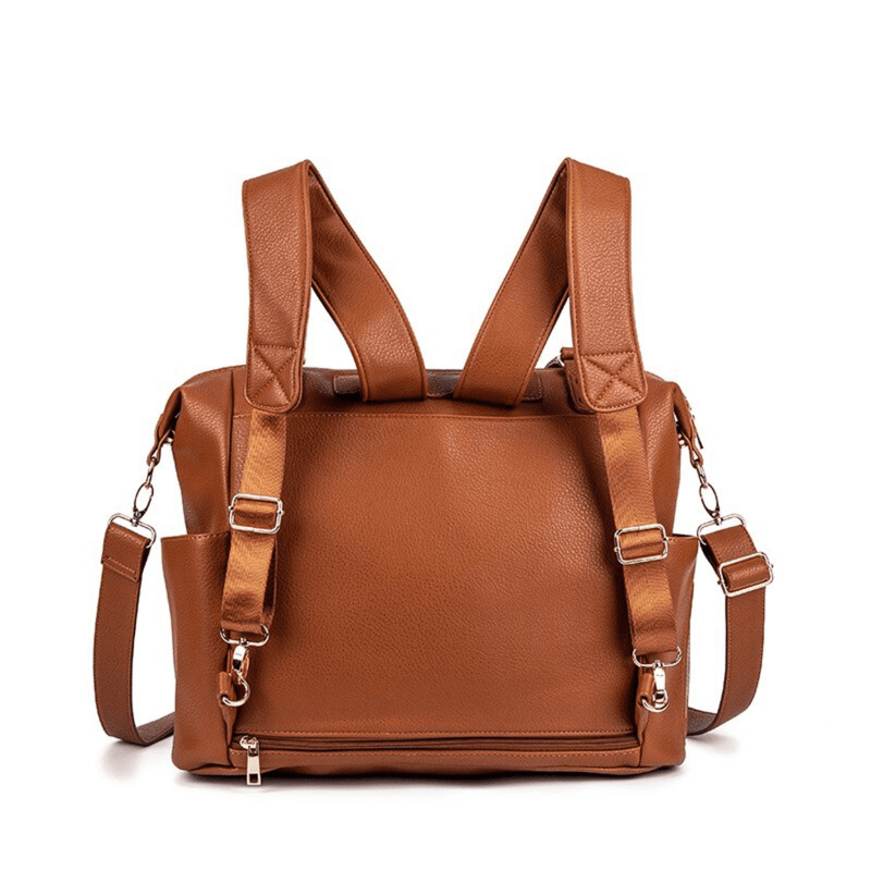 A Ivy - Caramel leather backpack with straps and buckles by Mother and Baby.