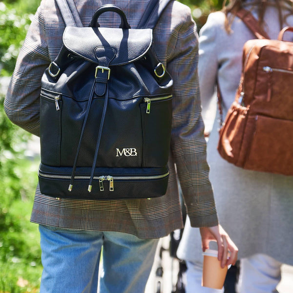 A man and woman walking down the street with a Mother and Baby Summer - Black backpack.