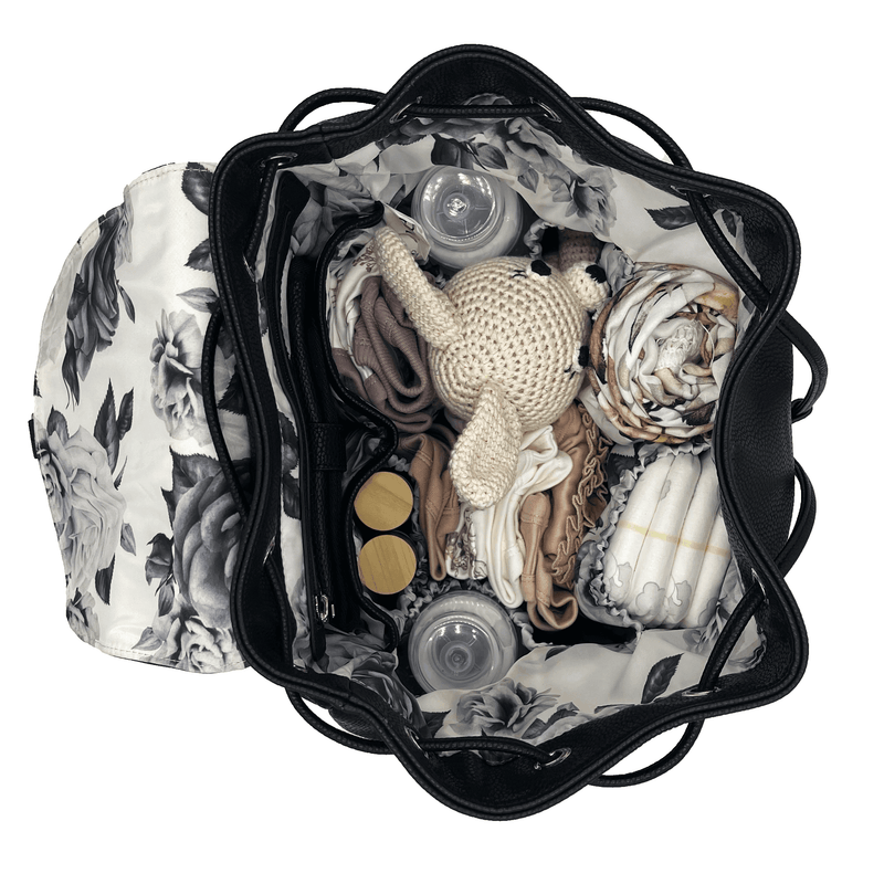 A Summer - Black diaper bag filled with diapers and other items.