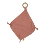 A pink Comforter Swaddle with a wooden ring attached to it by Mother and Baby.