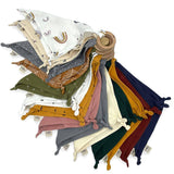 A bunch of Mother and Baby Comforter Swaddle bibs stacked on top of each other.