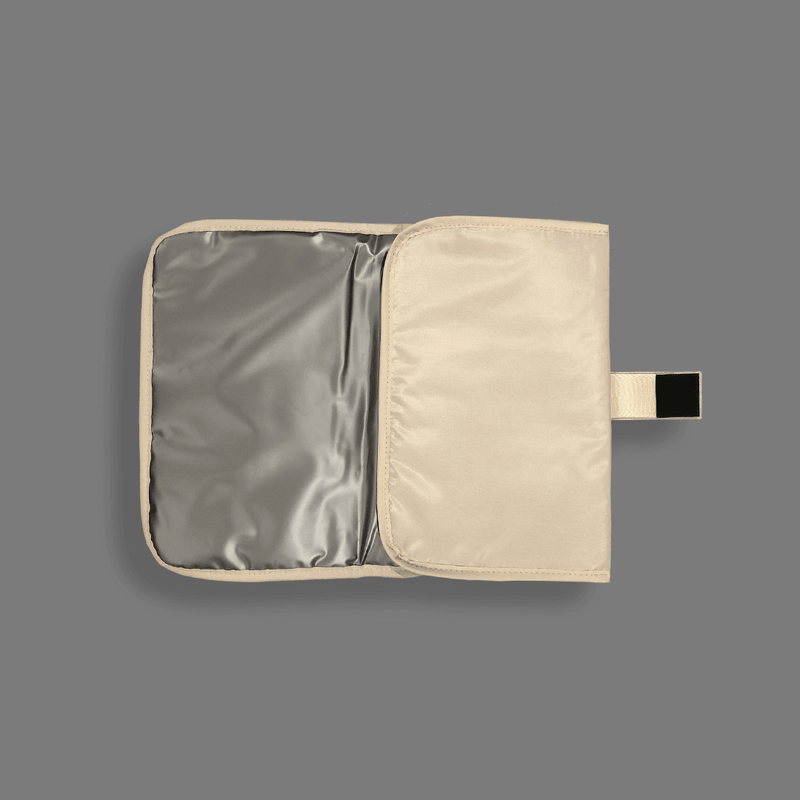 A Portable Changing Mat - Nude by Mother and Baby on a grey background.