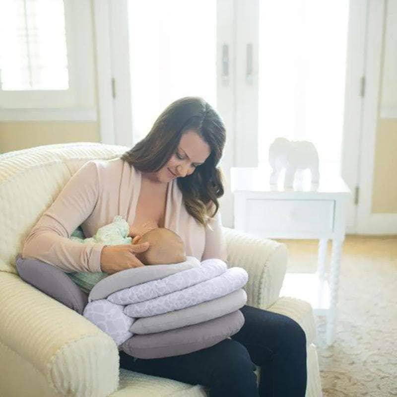A woman is breastfeeding her baby on the Adjustable Breast Feeding Pillow by Mother and Baby.